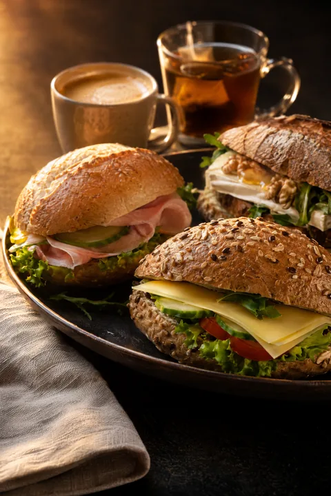 Compacte lunch met belegde broodjes en koffie of thee, snel geregeld voor een vergadering op kantoor.